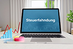 Aufgeklappter Laptop mit Schriftzug Steuerfahndung